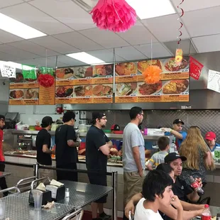 People going through the line ordering food.