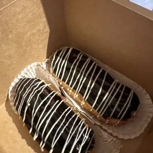two chocolate covered donuts in a box