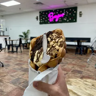 a person holding a sandwich in a restaurant
