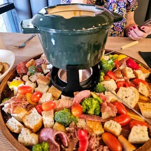 Classic Swiss cheese fondue with all of the goodies.  Bread, vegetables and salami.  Excellent!