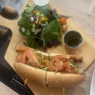 Shrimp po' boy &amp; salad, served on a custom board.