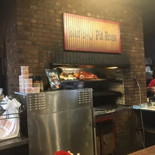 shows a man preparing food in a brick oven