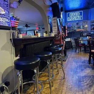 a bar with stools and a television