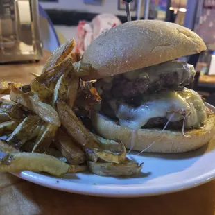 Bono Burger, two hand-made beef patties topped with grilled mushrooms and onions plus pepperjack cheese, with a side of fries.