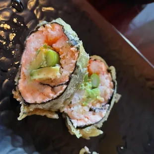 two pieces of sushi on a black plate