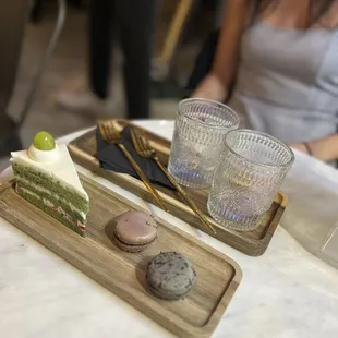 a woman sitting at a table with desserts