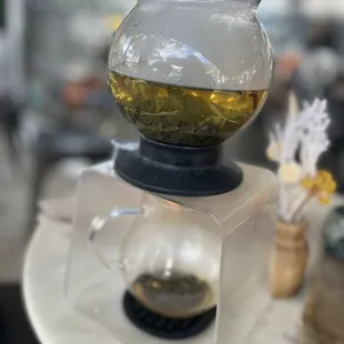 a glass teapot filled with green tea