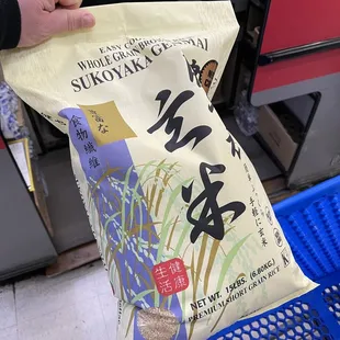 a person holding a bag of rice