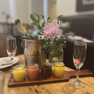 a wooden table with glasses of wine and a bottle of champagne