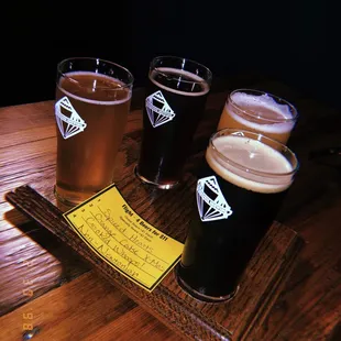 four beers on a wooden table