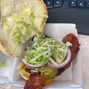 ows a bacon sandwich with lettuce and onions