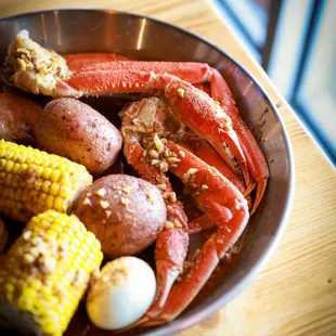 crab legs, corn, potatoes, and corn on the cob