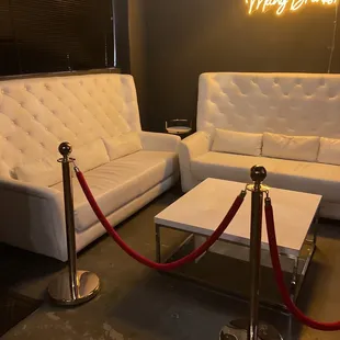 a white couch and a white couch with a red rope