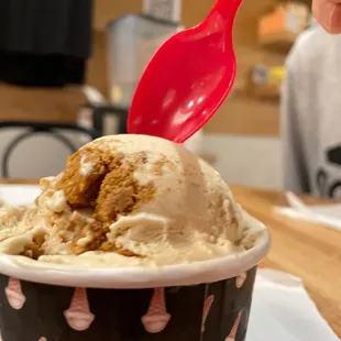 a person scooping into a cup of ice cream