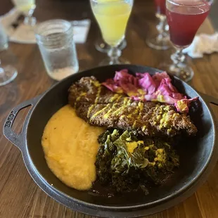 Catfish dinner, with grits, greens, and pickled cabbage.