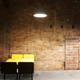 a brick wall and a yellow chair