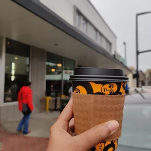 a hand holding a cup of coffee