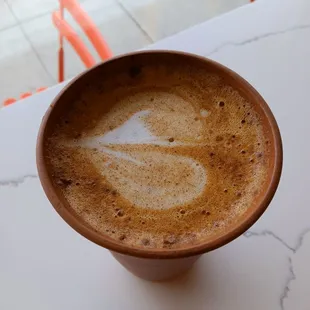 Personal unglazed naked mug beholds my oat house decaf latte.