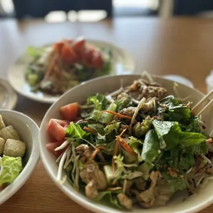 a bowl of salad with chopsticks