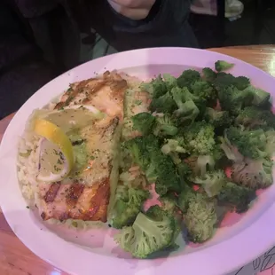Salmon, rice and broccoli. Twisted lemon slice on a bed of seasoned butter atop a perfectly grilled salmon.