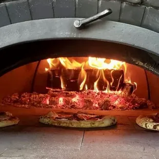 pizzas in a brick oven