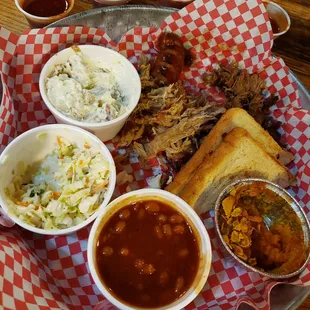 a platter of pulled pork, beans, coleslaw, coleslaw, coleslaw
