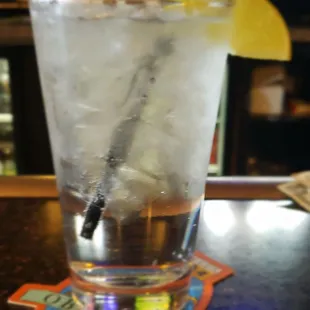 a glass of water with ice and a straw