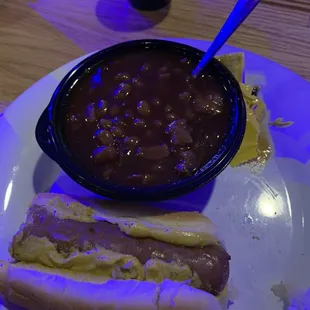 Bratwurst on a hot dog bun with bake beans.
