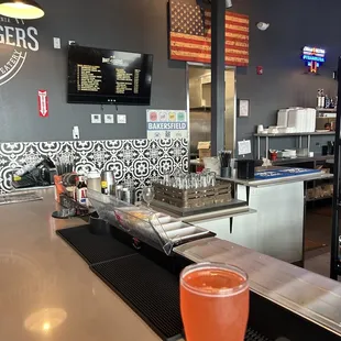 a glass of beer sitting on a bar