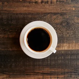 a cup of coffee on a wooden table