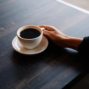 a person holding a cup of coffee