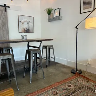 a living room with a rug, table, and chairs