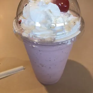 a purple drink with whipped cream and a cherry on top