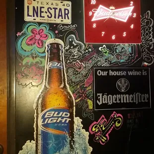 a beer bottle on ice in front of a neon sign