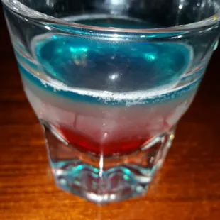 a blue and red drink in a glass