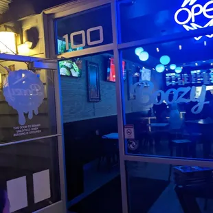 the entrance to a restaurant with a neon sign