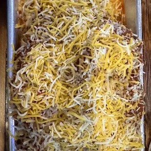 a pan of tacos with cheese on top
