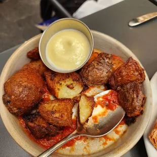 Potatoes in red sauce with a side dip