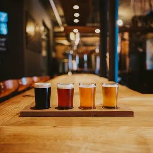 a row of beer glasses on a wooden table