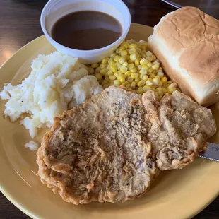 Fried PorkChops, mashed potatoes, corn, brown gravy, and dinner rolls.
