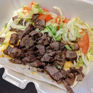 Beef tacos (side) with veggie toppings and cheese on a flour tortilla for a fun meal.