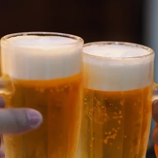 two people toasting with beer