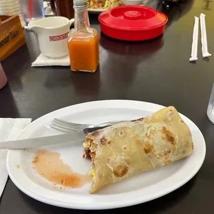 a white plate with a burrito on it