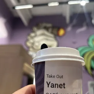 a hand holding a take out coffee cup