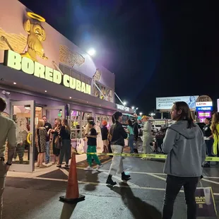 a crowd of people standing outside of a store