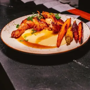 Roasted chicken, mashed potatoes and cooked carrots.