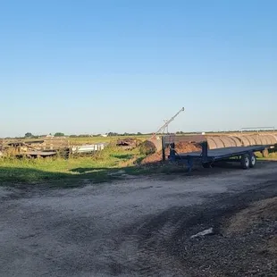 a tractor pulling a trailer down a dirt road