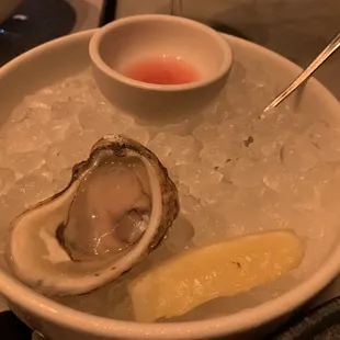 a bowl of oyster and a lemon wedge