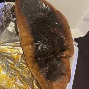 Burned bottom of soggy calzone.