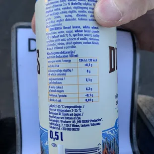 a hand holding a can of beer